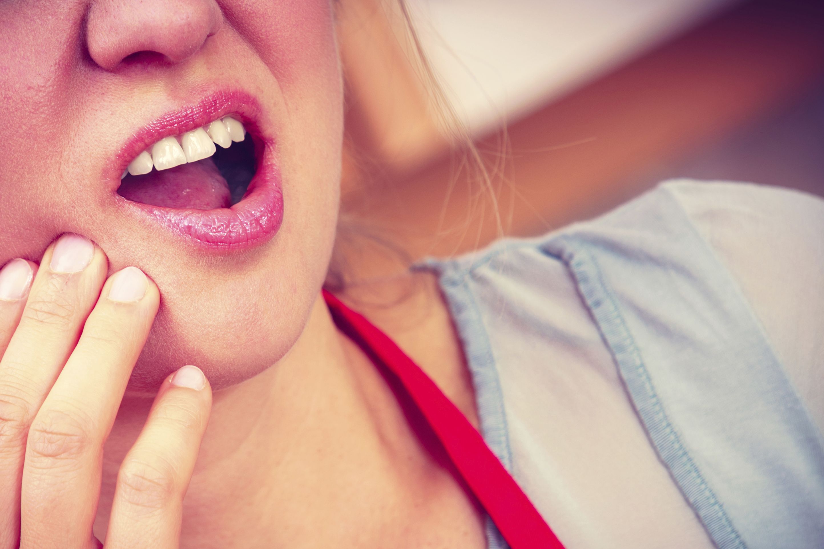 Woman holding jaw in pain